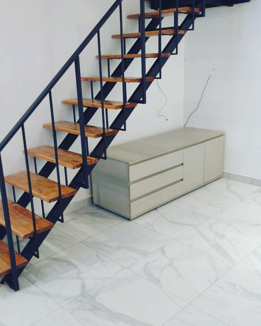 Escalera de hierro con pedadas de madera sobre piso símil mármol